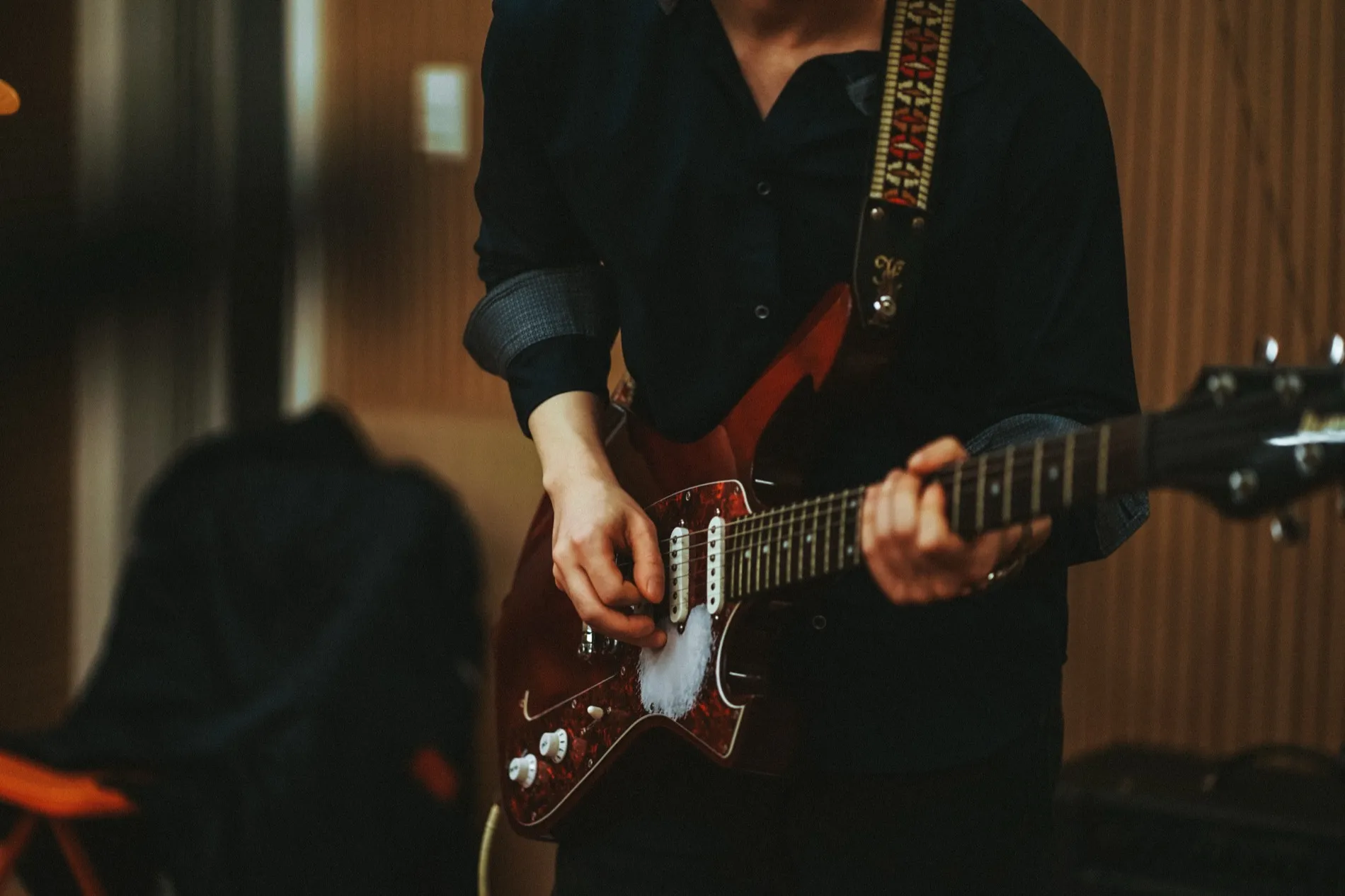 A guitarist playing in the warm wood-panelled live room at Jam in SeouL