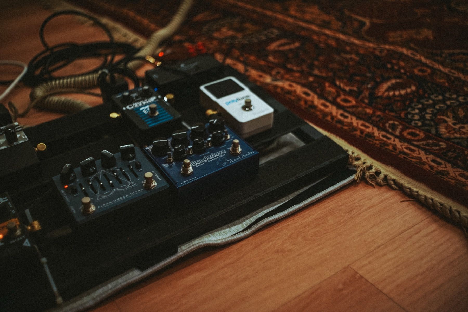A pedalboard resting on the studio rug