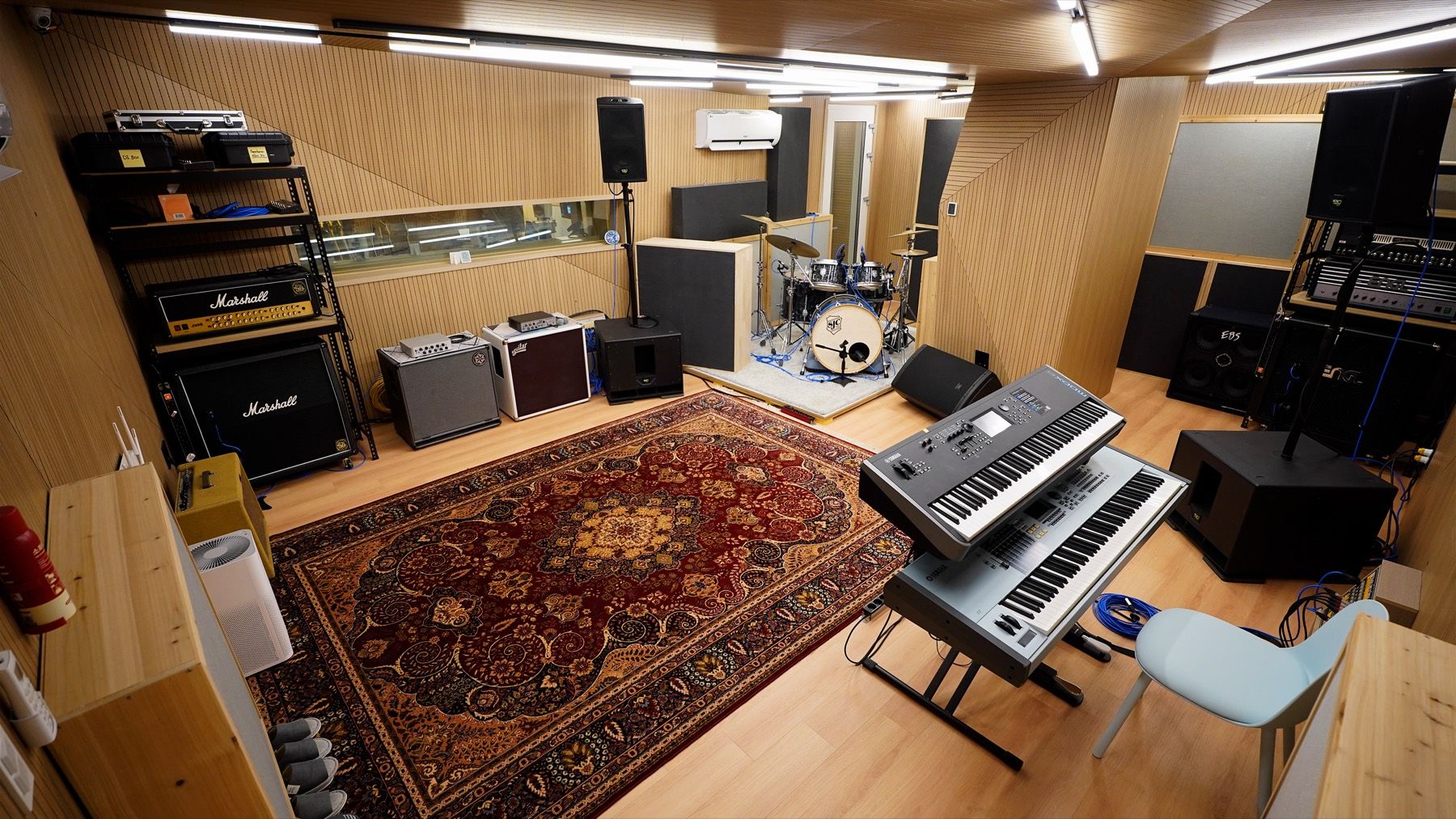 The warm wood-panelled live room with drums, amps and keys